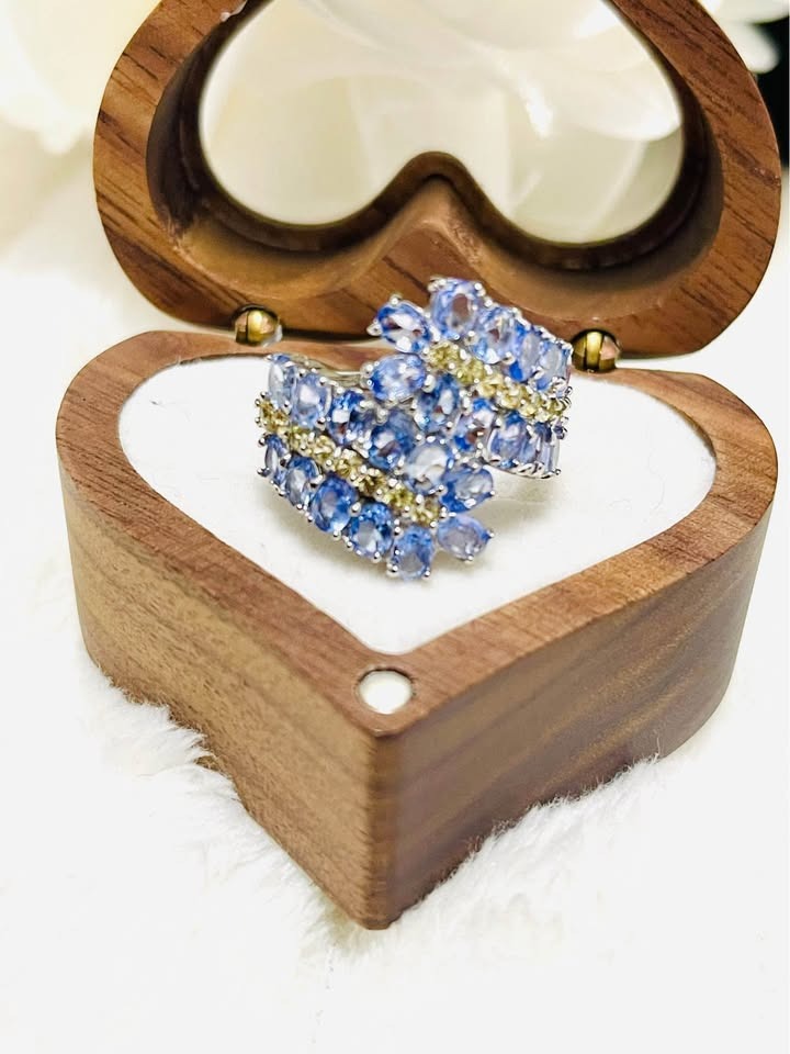  A stunning sterling silver ring with natural tanzanite and sapphire gemstones, presented in a heart-shaped box.