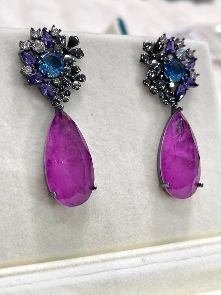 Angled view of striking Paraiba tourmaline drop earrings, sterling silver with rhodium plating.