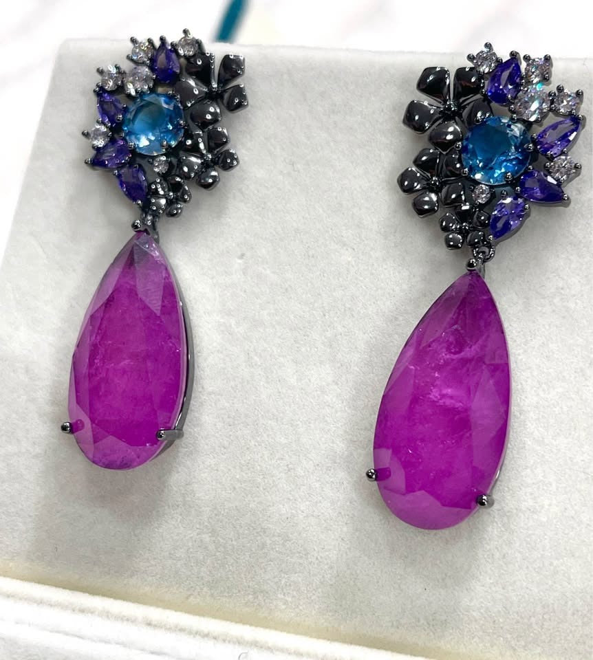 Close-up of exquisite Paraiba tourmaline and sterling silver rhodium-plated dangle earrings.