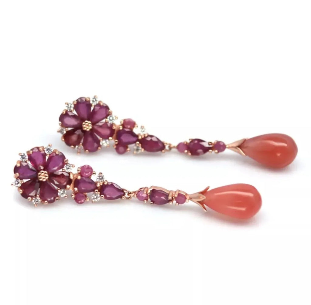 Flat lay of stylish prehnite and ruby dangle earrings, highlighting their long design and gemstone arrangement.