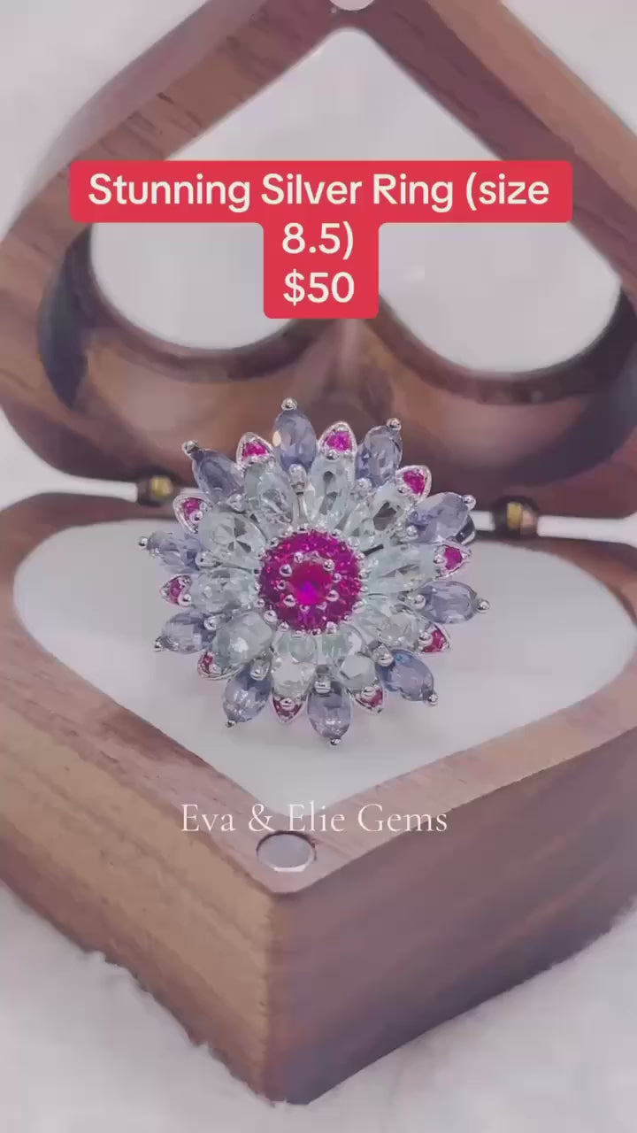  An elegant silver ring with a large blue gemstone as the centerpiece.