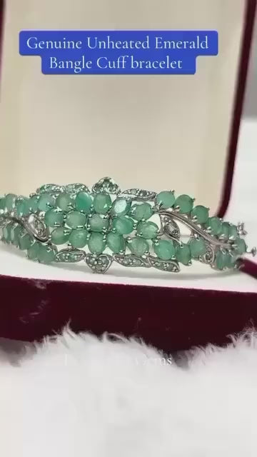 Exquisite genuine unheated Emerald floral bangle cuff bracelet. Elegant green gemstone design.
