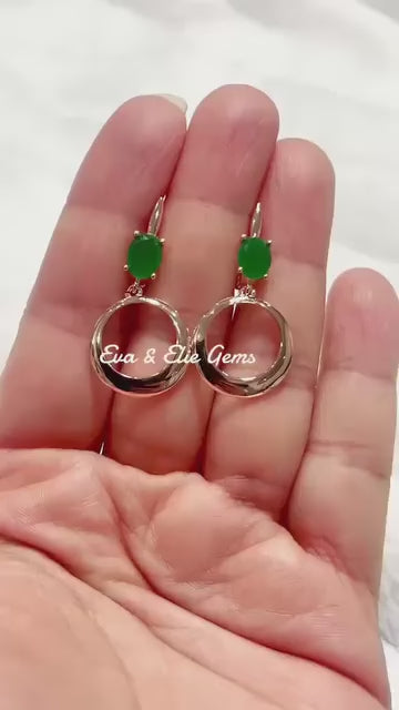 These beautiful earrings feature a polished gold hoop with a faceted green emerald stone.