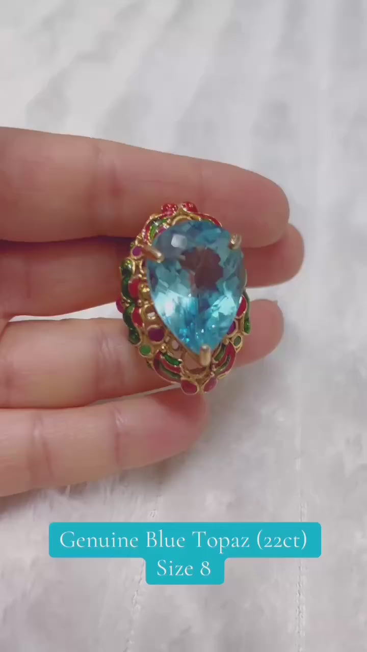 Exquisite handmade royal ring featuring a large blue topaz and colorful gemstones.