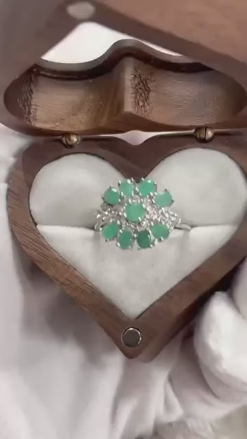 Elegant ring showcasing multiple natural emerald gemstones in a delicate flower design.