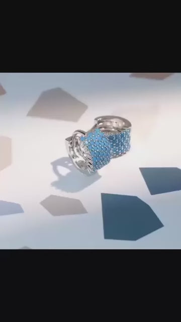  A pair of sterling silver wide pave huggie hoop earrings featuring genuine turquoise stones.