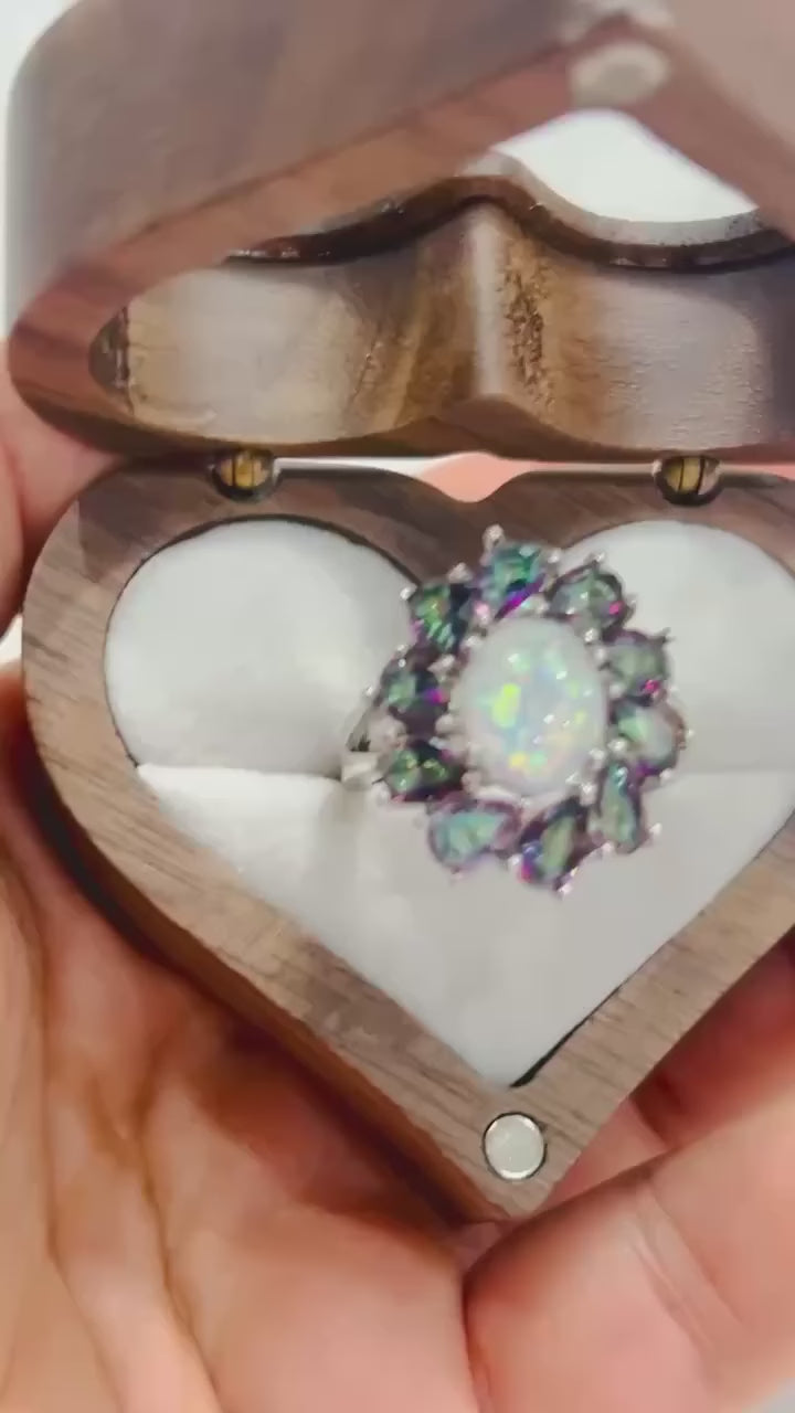 Exquisite ring with a large opal gemstone surrounded by a halo of mystic topaz.