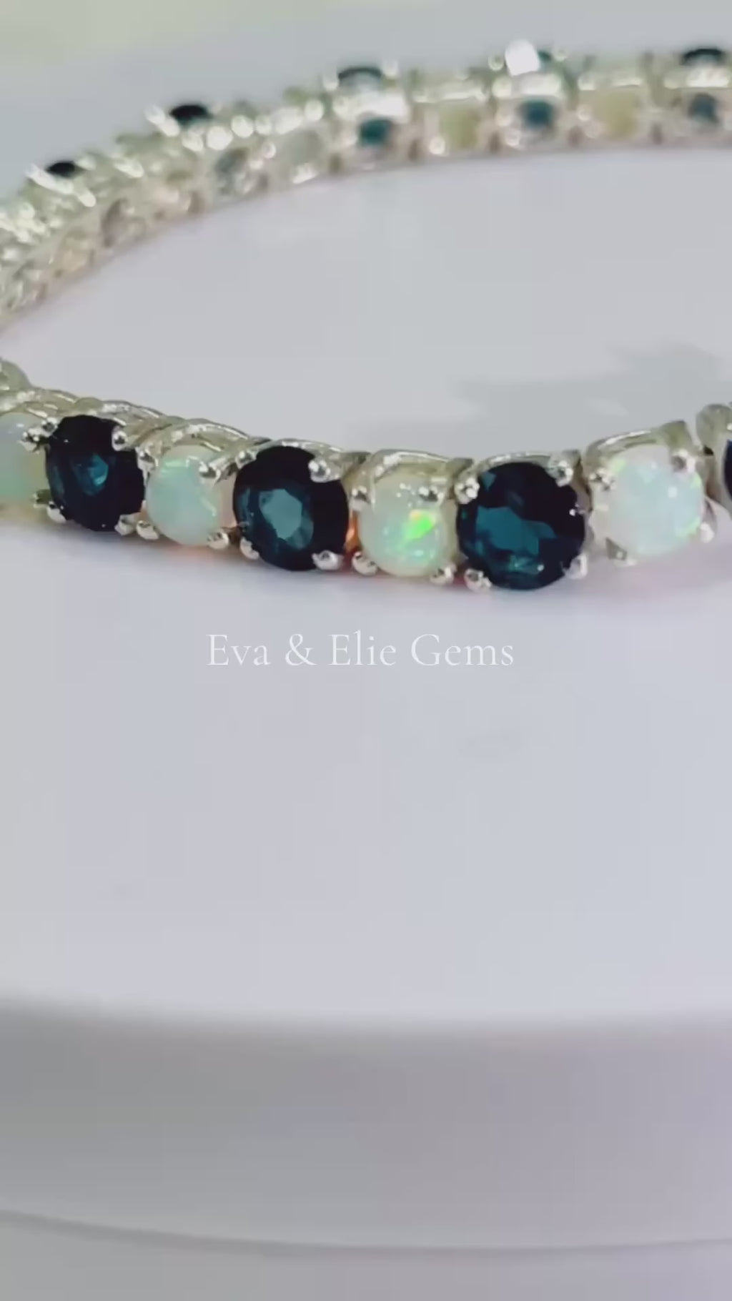 Beautiful London Blue Topaz and Opal tennis bracelet. Blue and iridescent gems in a classic setting.
