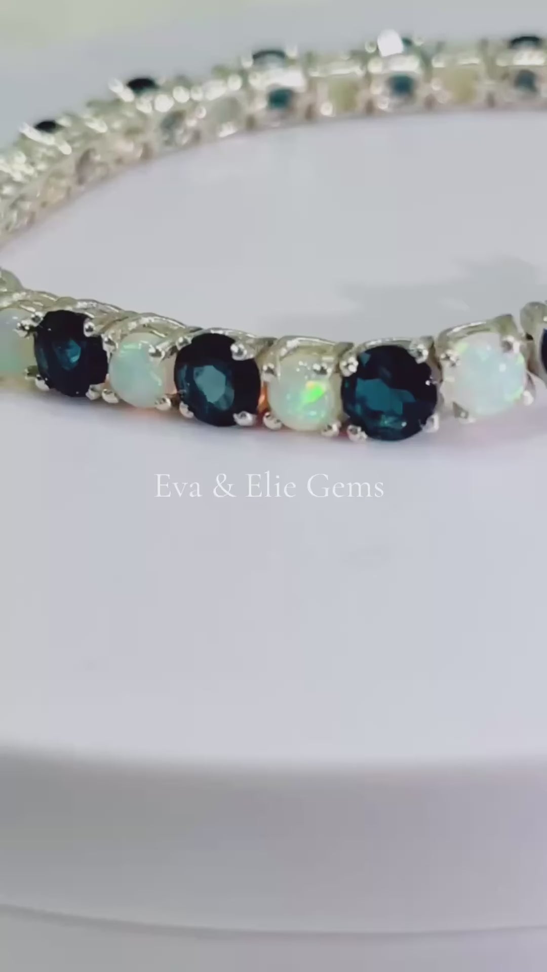 Beautiful London Blue Topaz and Opal tennis bracelet. Blue and iridescent gems in a classic setting.