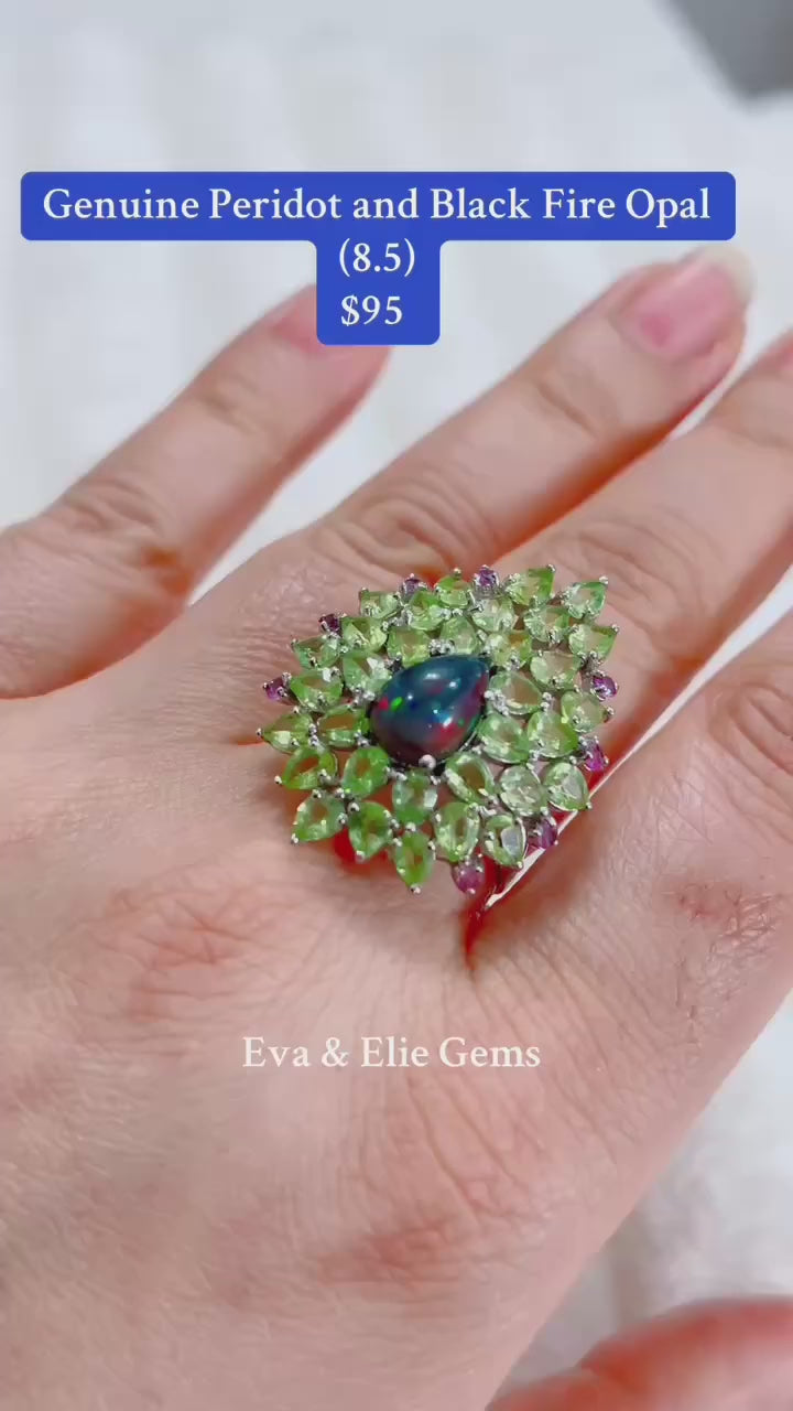  A stunning ring featuring a genuine black fire opal surrounded by peridot and pink gemstones.