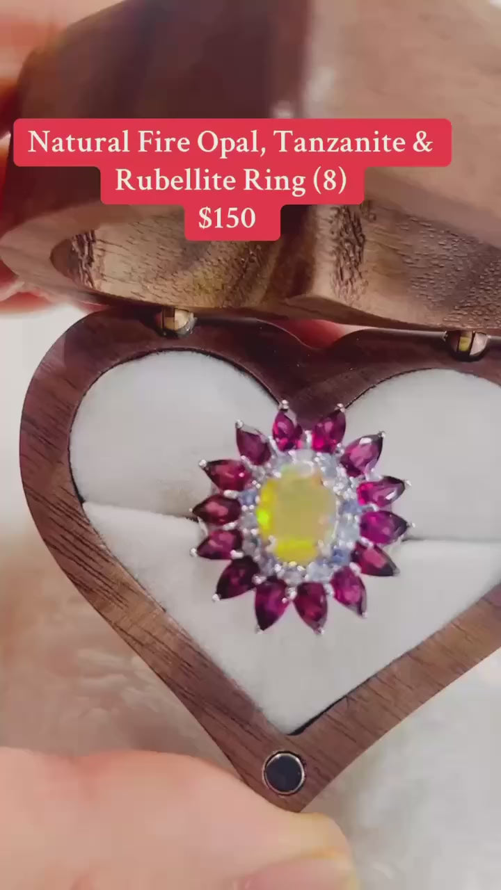  A stunning ring featuring a fire opal with a halo of rubellite and tanzanite gemstones.