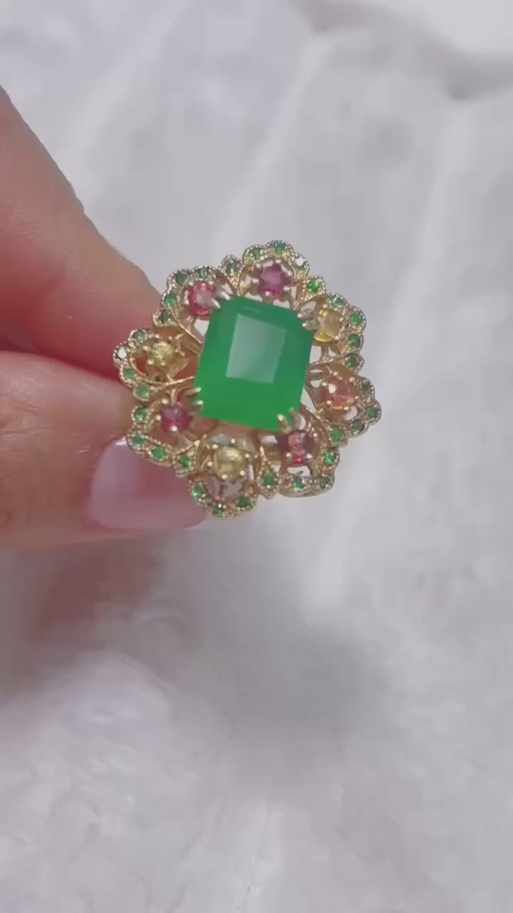  A stunning ring with a natural emerald centerpiece surrounded by sapphires, diopside, and agate.