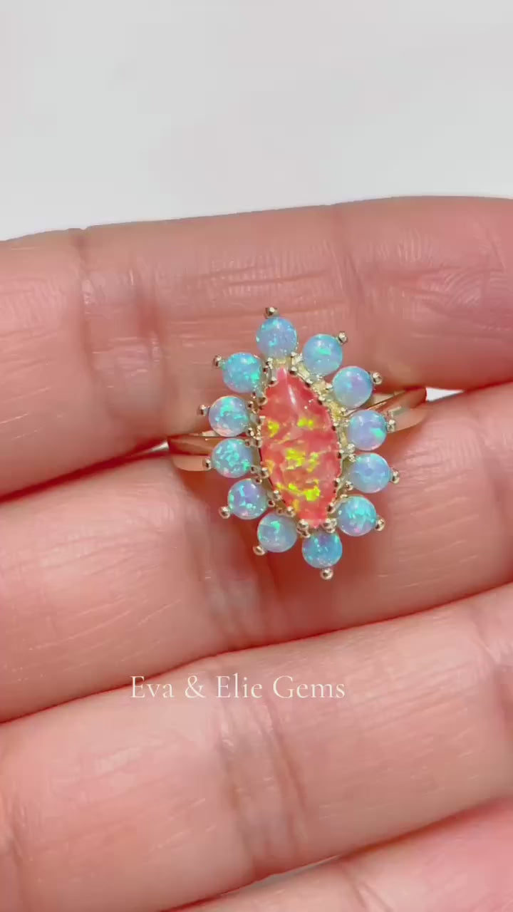 Unique sterling silver ring showcasing a fiery orange opal surrounded by blue opals.