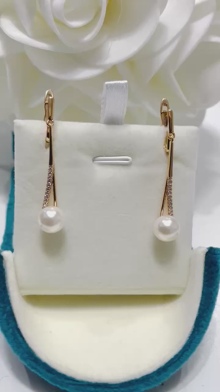 Elegant long gold filled earrings with lustrous dangling pearls and clear accents.