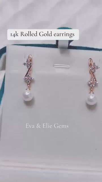  Elegant 14k rolled gold pearl dangle earrings with floral accents.