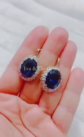 These exquisite earrings feature large, oval blue sapphires in an elegant halo design.