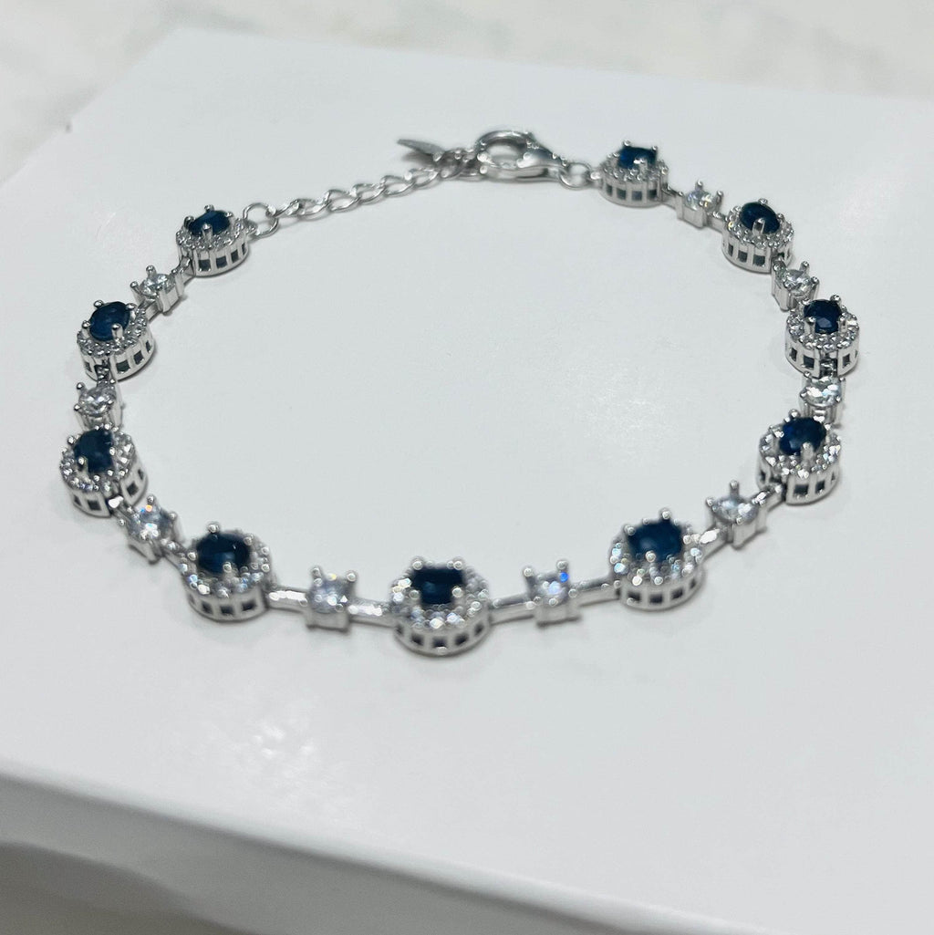 Angled perspective of a rhodium-plated sapphire bracelet, highlighting the brilliant blue gemstones and shimmering accents.