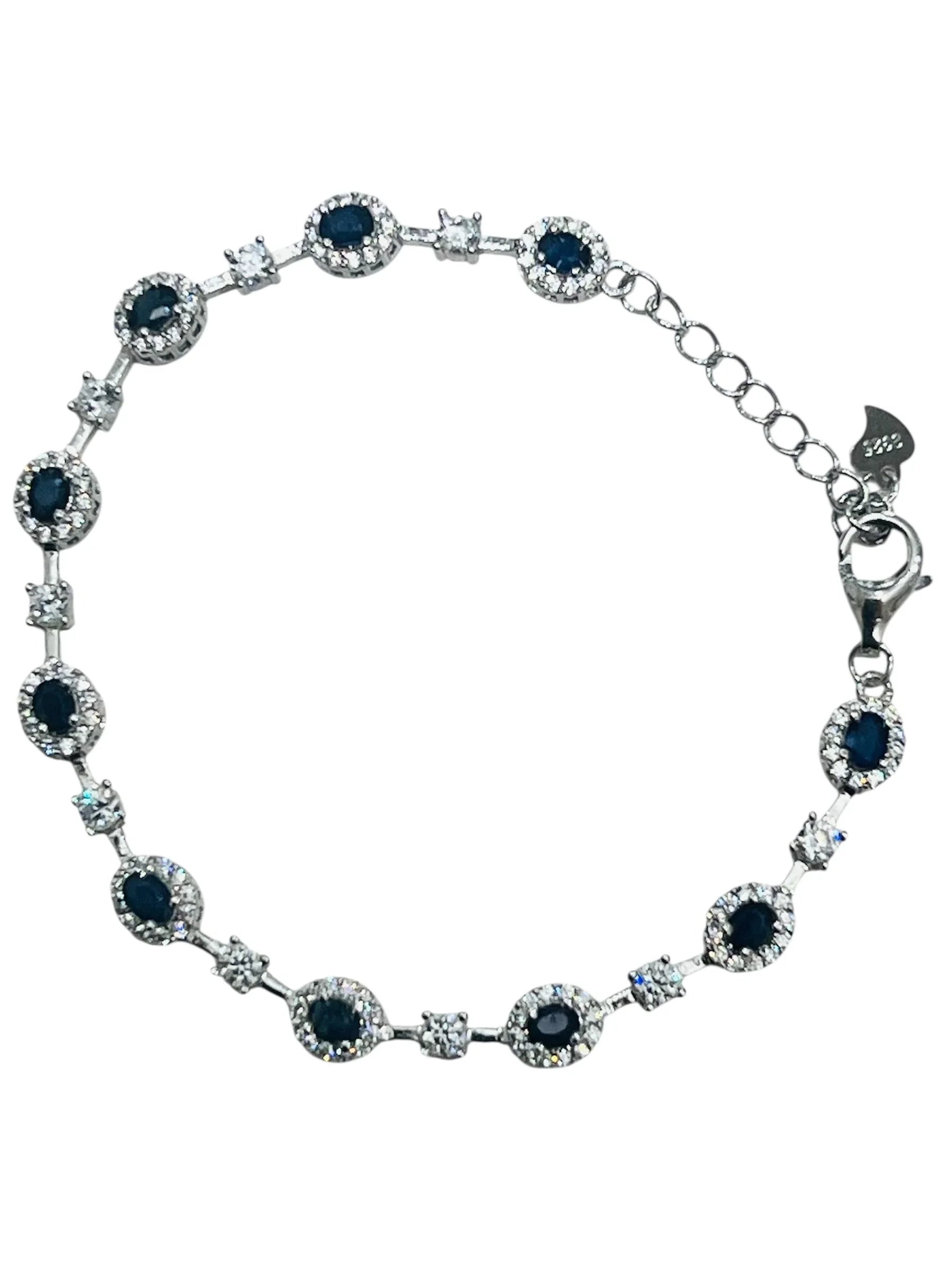 Rhodium-plated bracelet with blue sapphires and white accent stones on a white background.