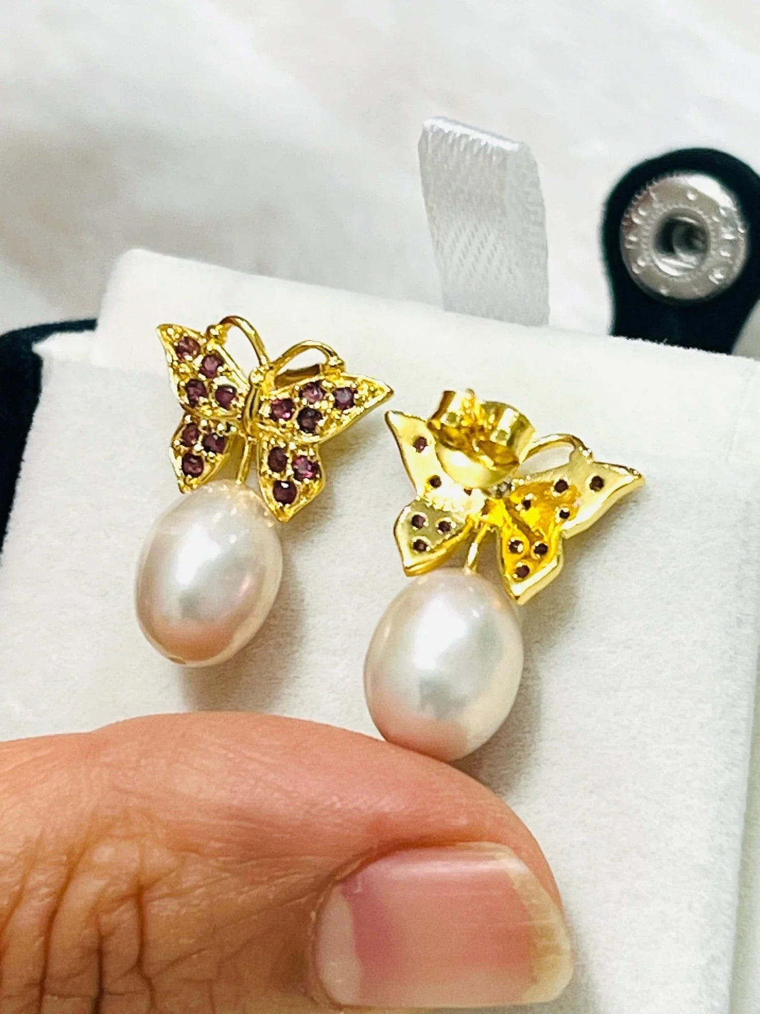 Rhodolite garnet butterfly earrings with pink pearl drops, showing both the front and back of the delicate gold settings.