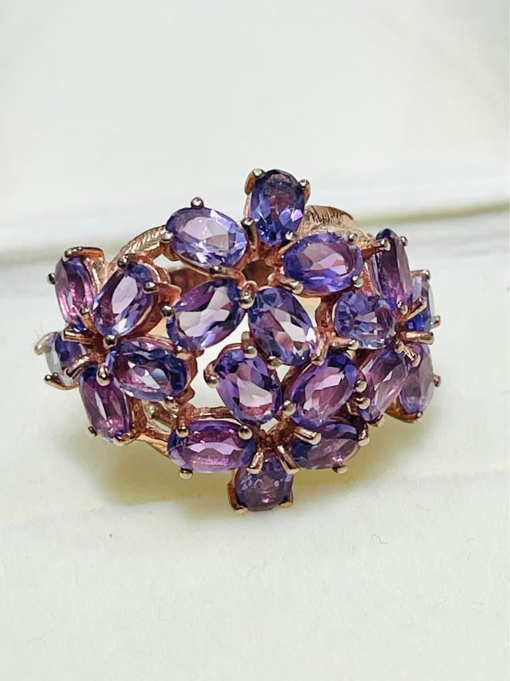 Exquisite rose gold cocktail ring with a vibrant amethyst cluster bloom design, top view.