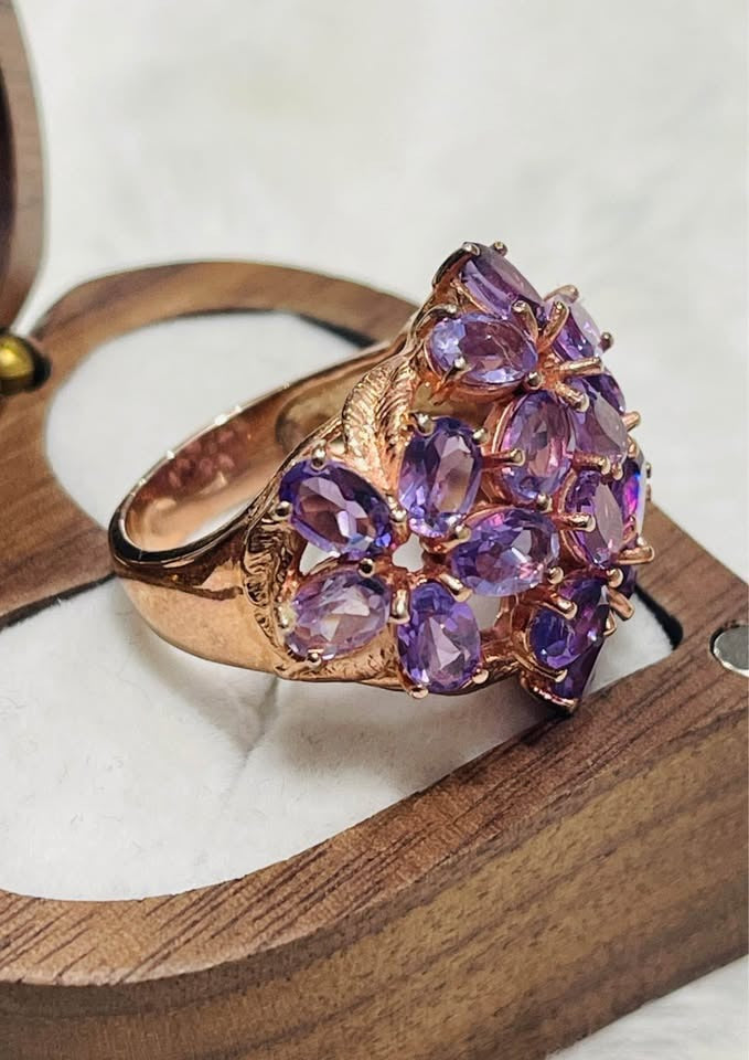 Side profile of a rose gold amethyst cluster cocktail ring, showcasing intricate detailing in its box.