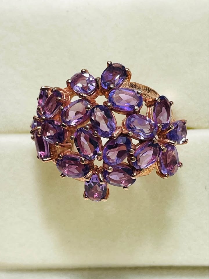 Close-up of a luxurious rose gold cocktail ring featuring multiple oval amethyst gemstones.