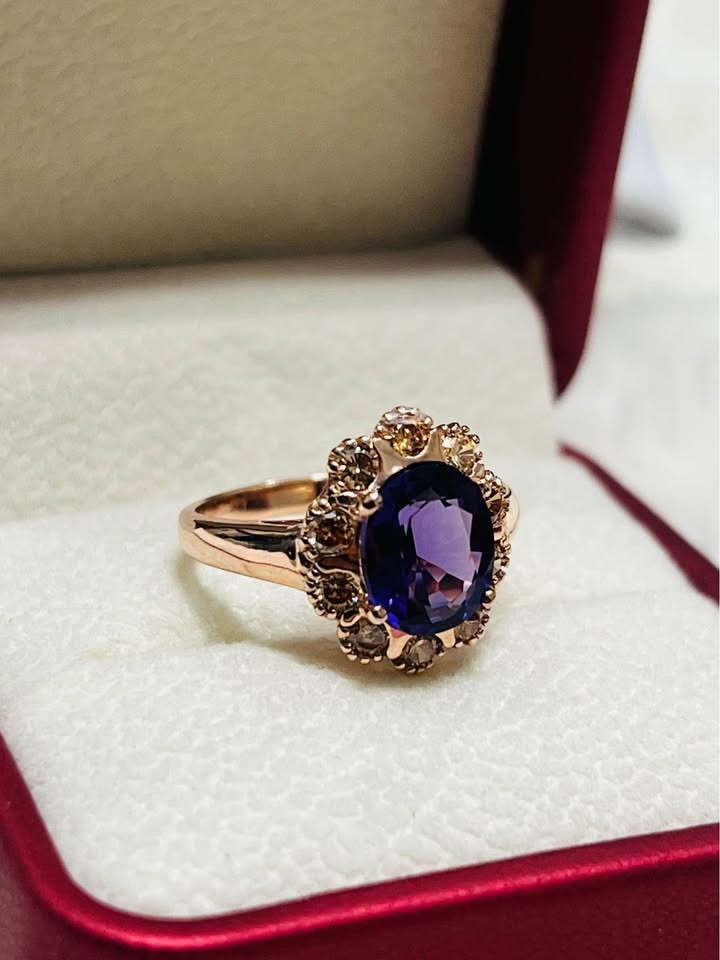  Angled view of a beautiful rose gold sterling silver ring with a vibrant amethyst and champagne sapphire halo, in a gift box.