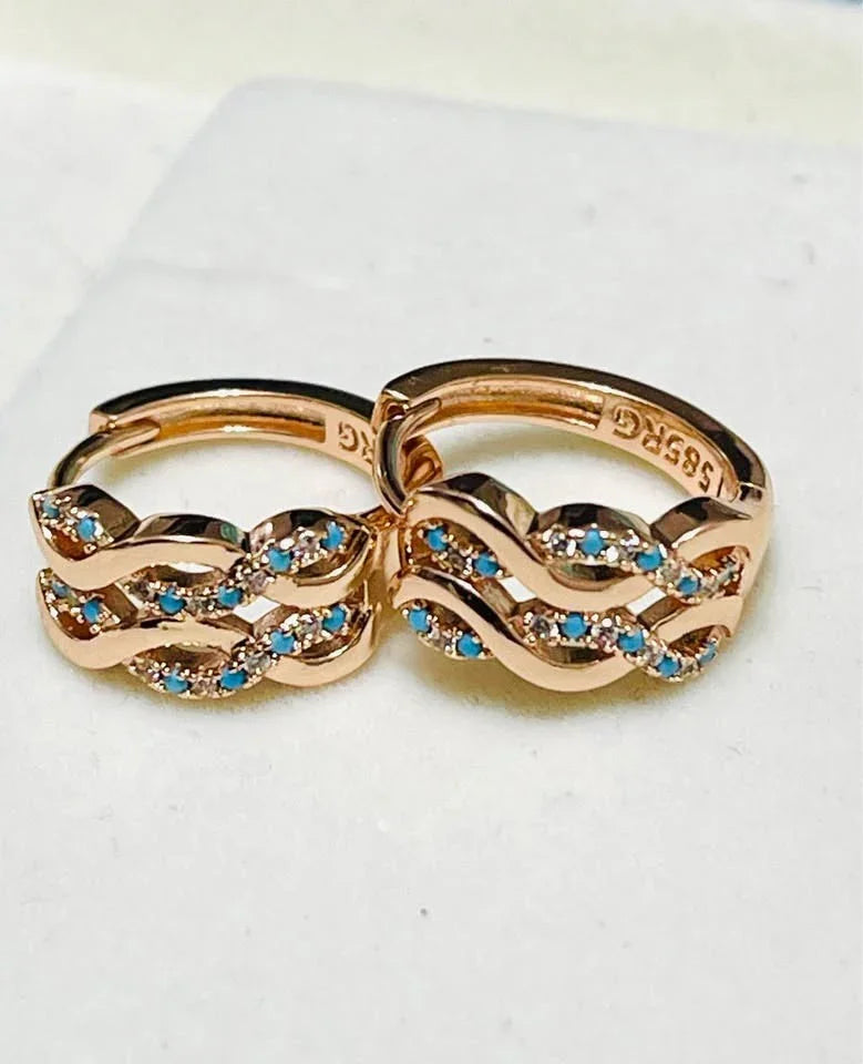 Close-up of 14k 585RG rose gold huggie hoops, showing the intricate waves of turquoise gemstones.
