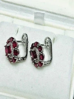 Side view of ruby and diamond halo earrings, showcasing the sterling silver setting and secure latch-back closure mechanism