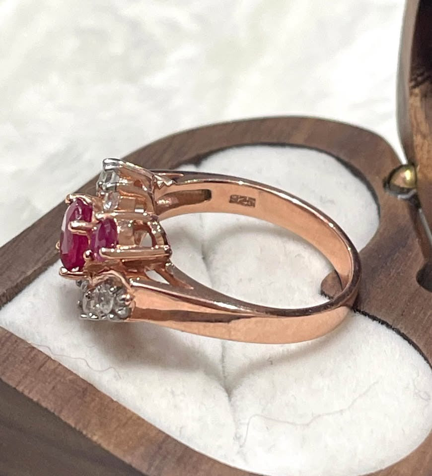 Side view of a stunning 18K rose gold plated ring with natural Burmese rubies and white topaz accents.