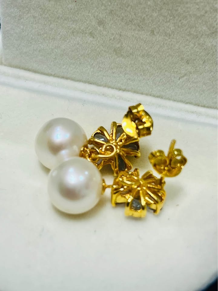 Back view of South Sea pearl earrings with tanzanite and ruby details in a gold setting.