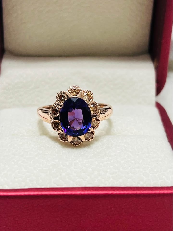 Exquisite sterling silver ring featuring a dazzling amethyst centerpiece and sapphire halo, presented in a red jewelry box.