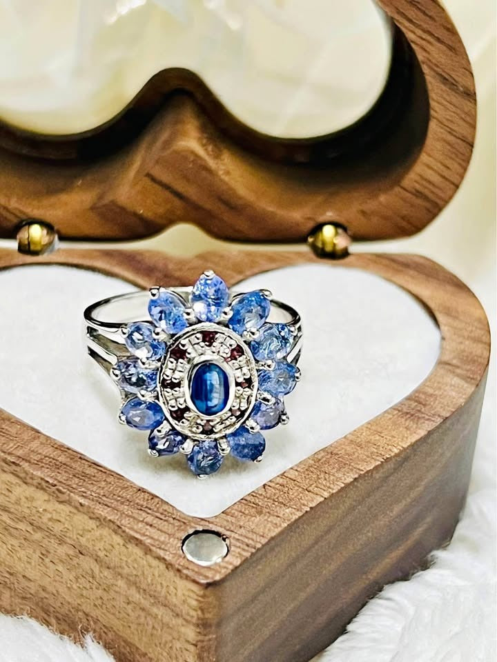  A natural sterling silver tanzanite flower ring with a stunning blue gemstone cluster on a white background.