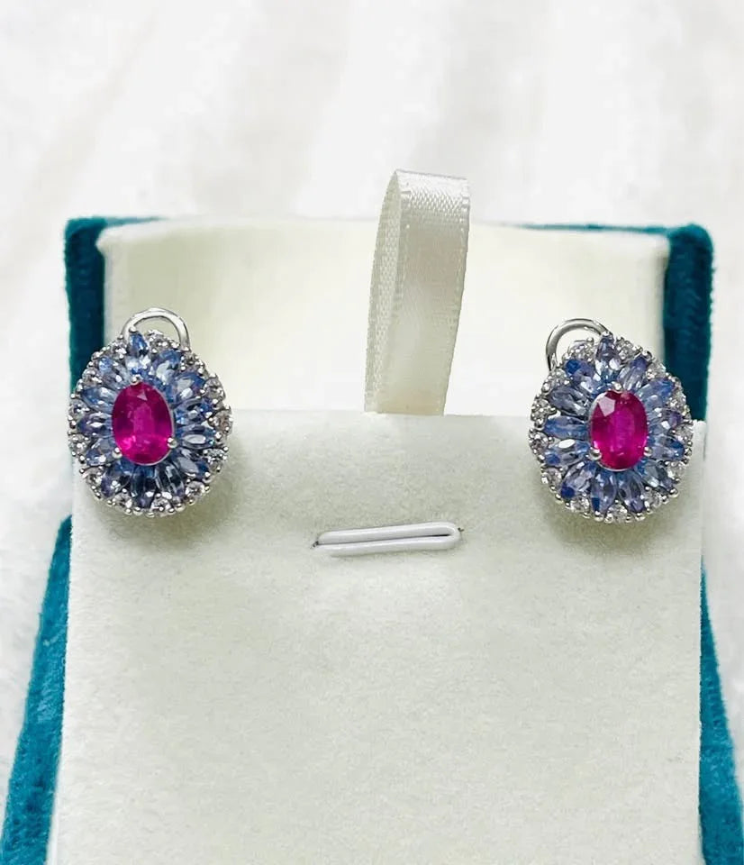 Natural sterling silver earrings with vibrant tanzanite and ruby gemstones, presented in a plush jewelry box.