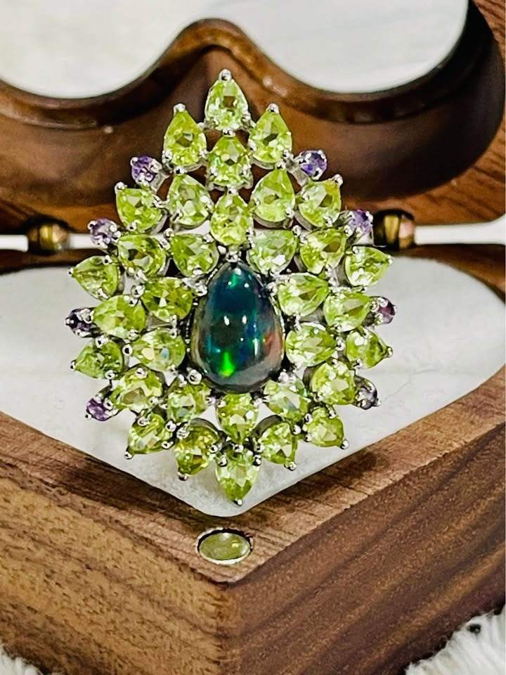  Stunning black fire opal ring with a vibrant cluster of peridot and amethyst accents.