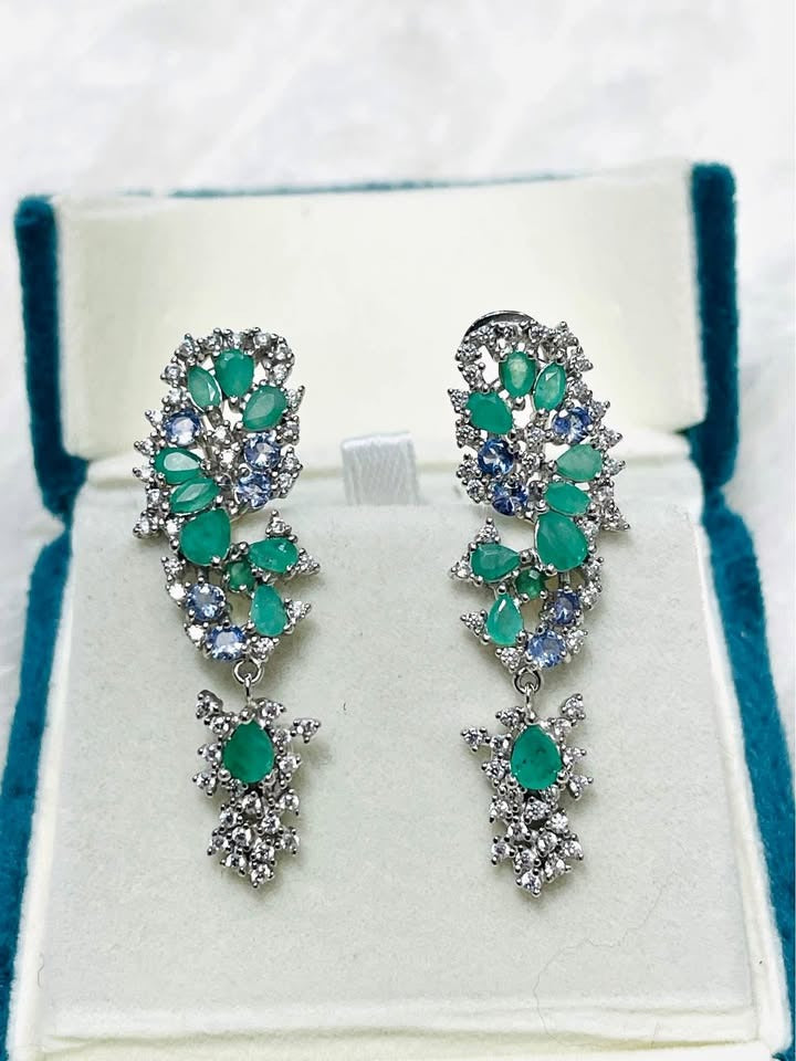 Stunning drop earrings featuring a cluster of emerald and tanzanite gems in a delicate, fancy setting.