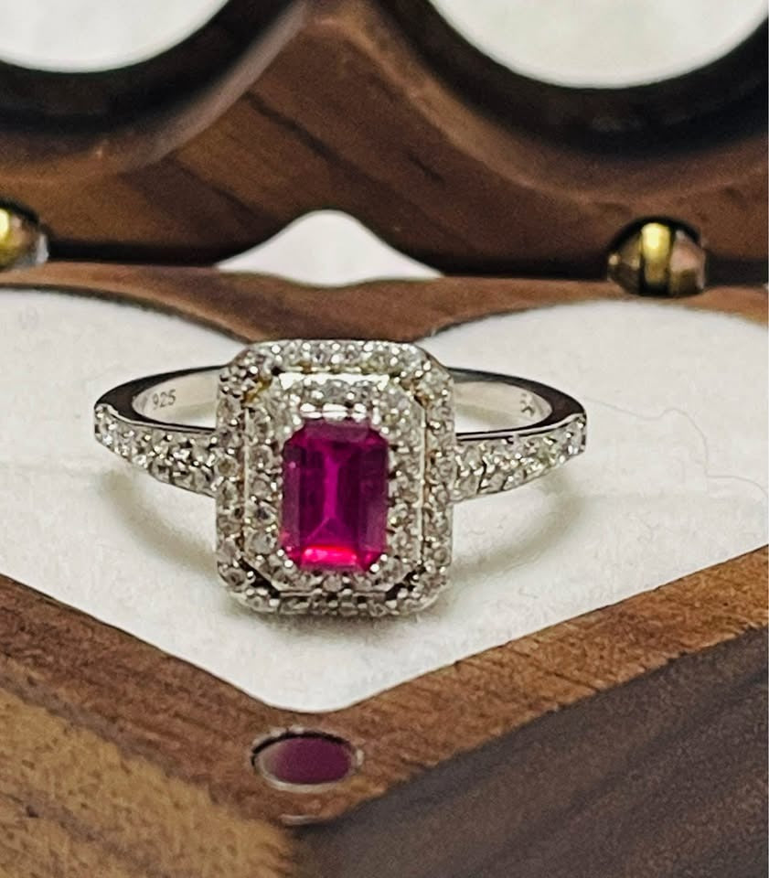A stunning natural ruby gemstone ring with a brilliant diamond halo and accent stones on the band.