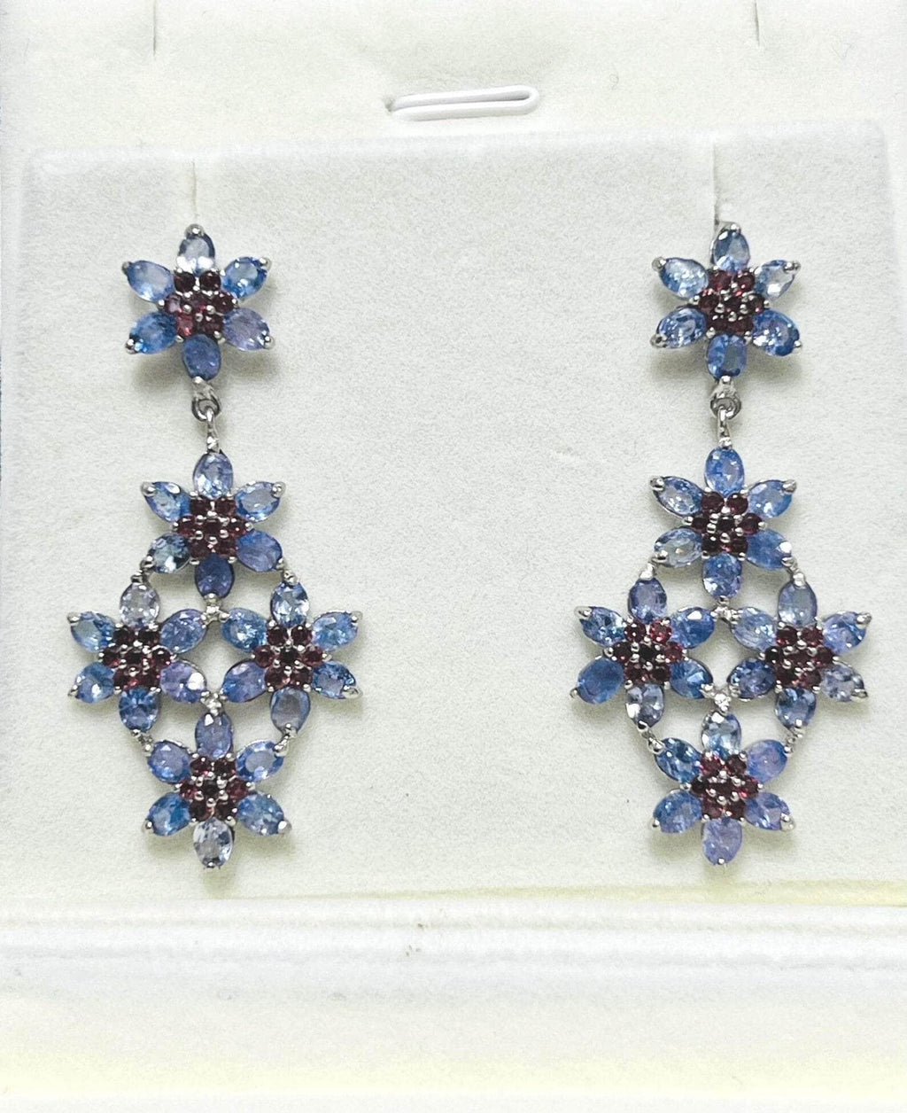  Pair of exquisite floral dangle earrings with blue tanzanite and red garnets, perfect for special occasions.