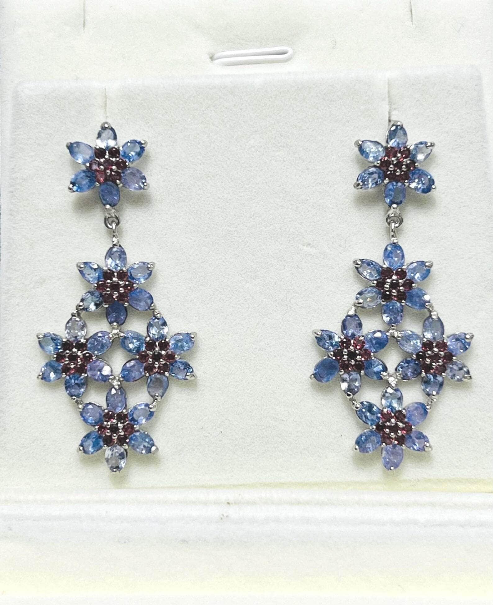  Pair of exquisite floral dangle earrings with blue tanzanite and red garnets, perfect for special occasions.