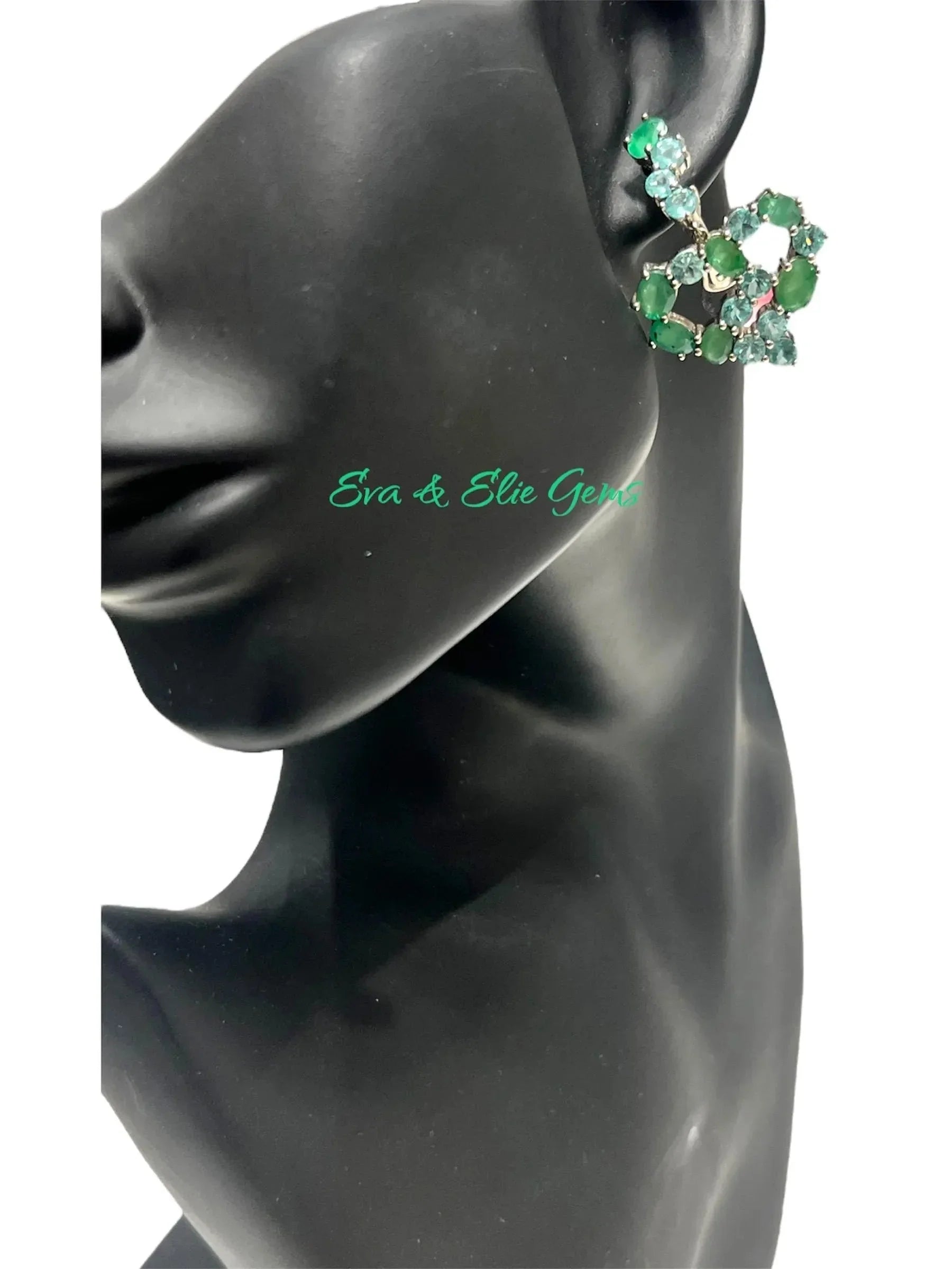 Close-up of a mannequin wearing a vintage emerald and apatite cluster earring, highlighting its design.