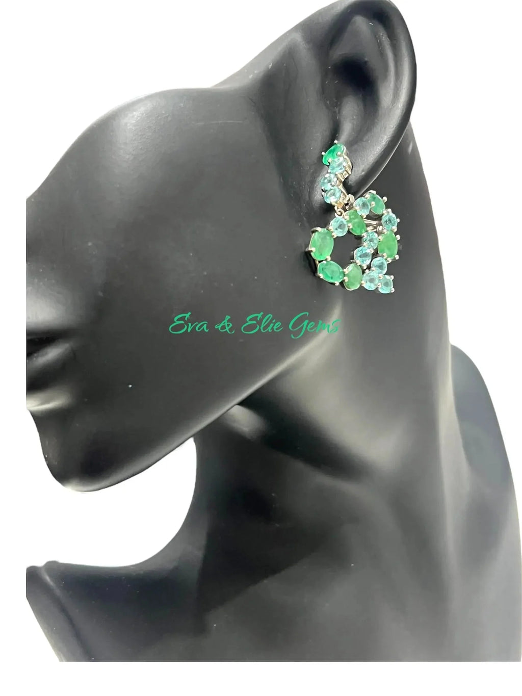 Side profile of a mannequin wearing a vintage emerald and blue apatite dangle earring, showing its drop.