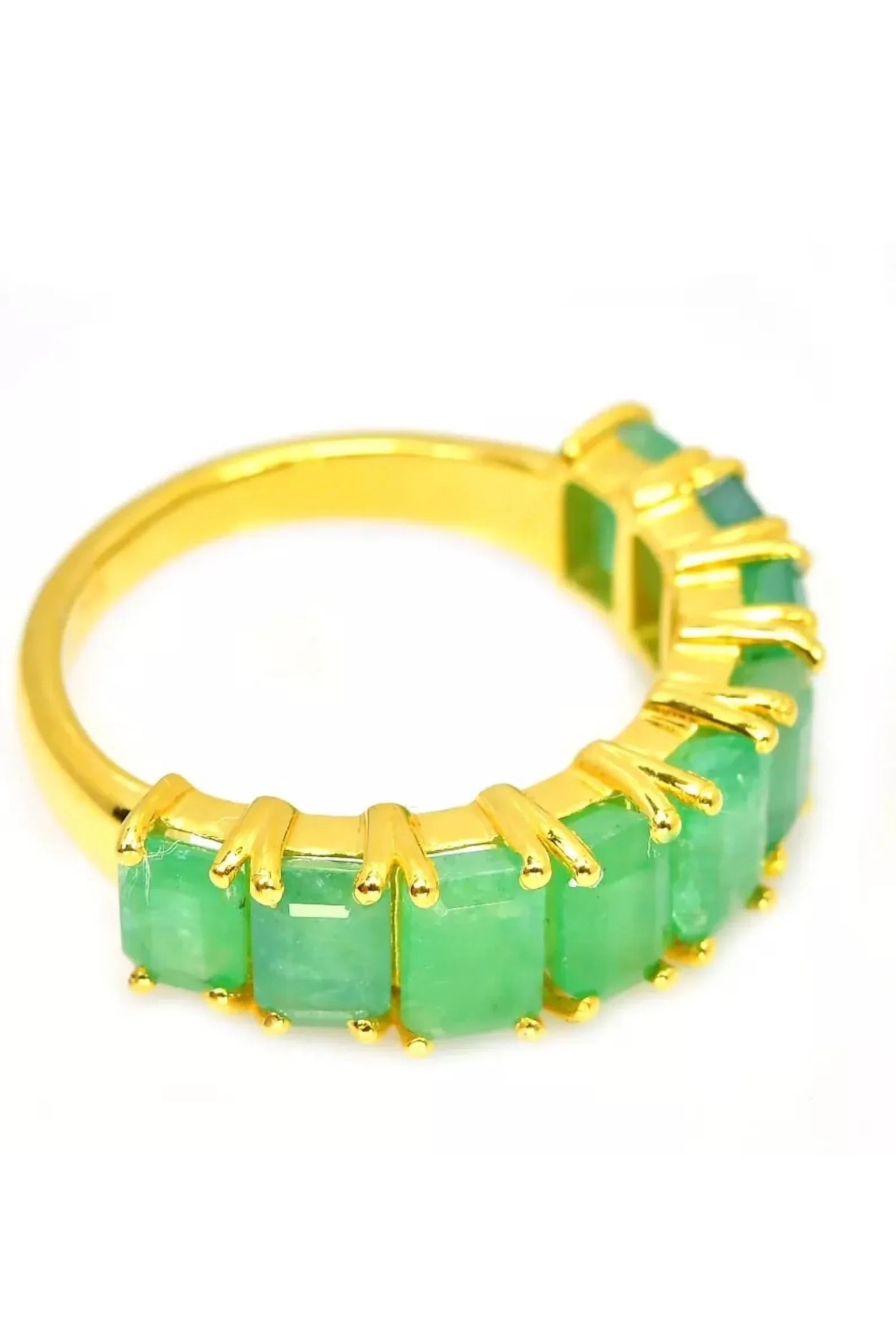 Elegant Zambian emerald flower ring worn on a finger, showcasing its vibrant green gemstones and sparkle.