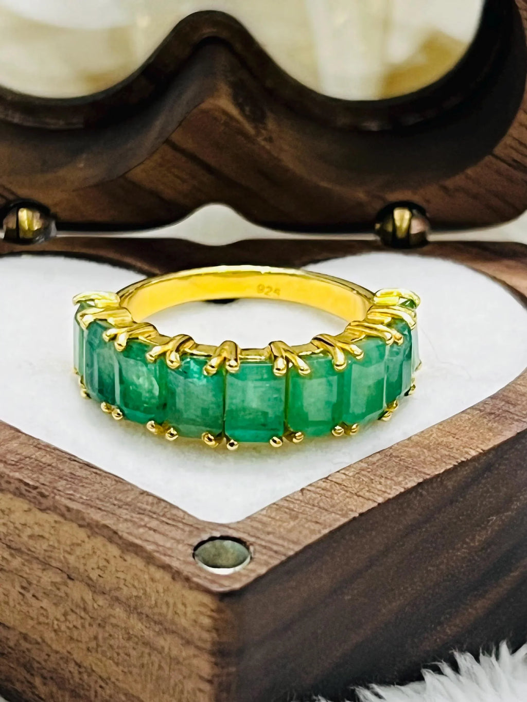 Side view of a Zambian emerald flower ring, highlighting its sterling silver band and raised gemstone setting.