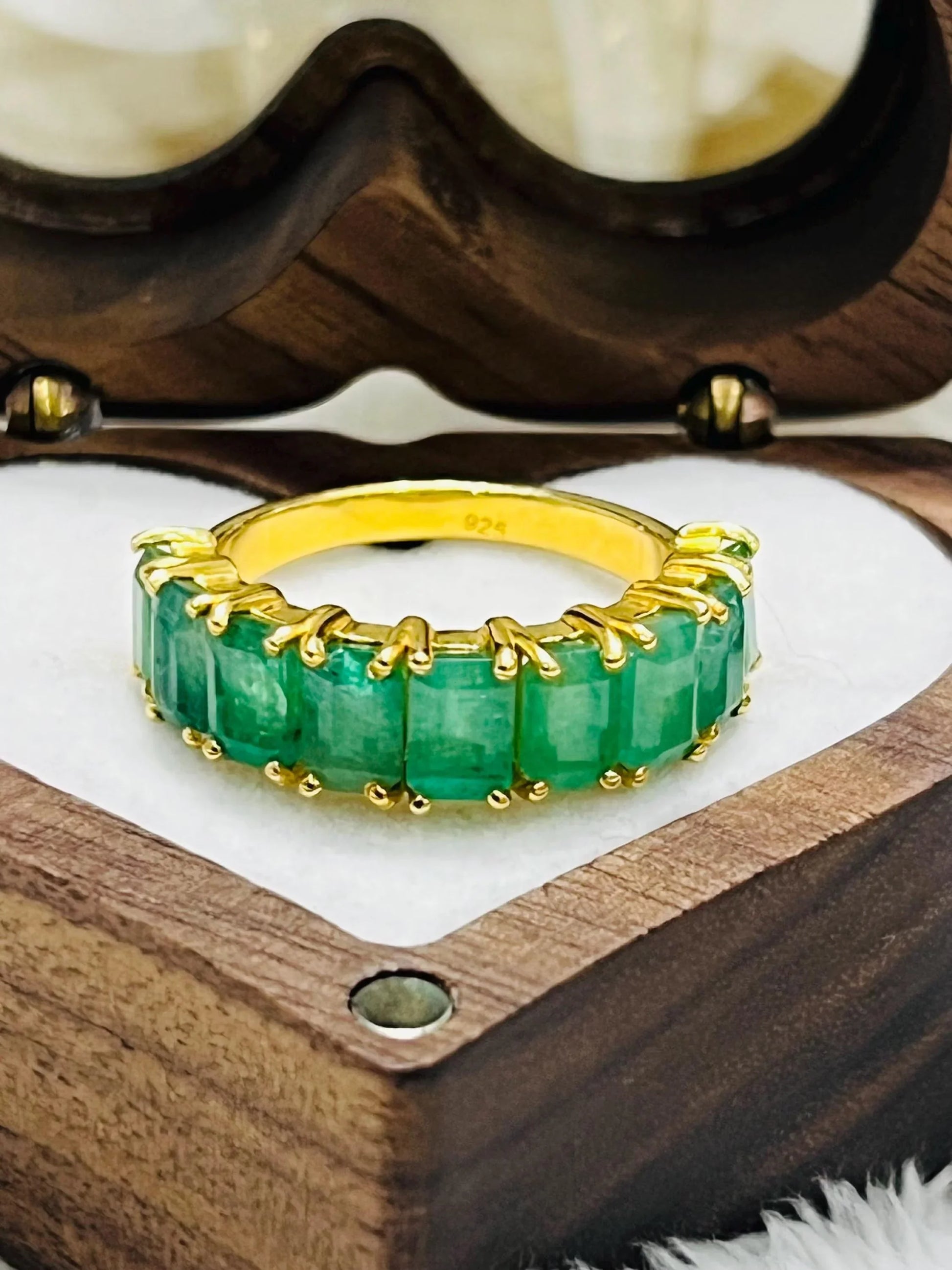 Side view of a Zambian emerald flower ring, highlighting its sterling silver band and raised gemstone setting.